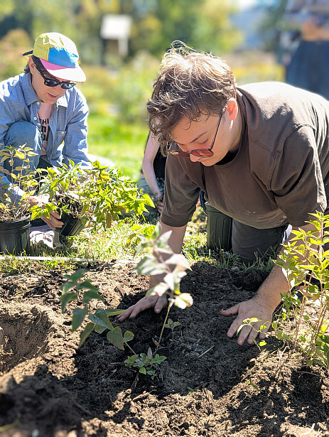 Jaiden planting Student planting in Native Plant Garden
