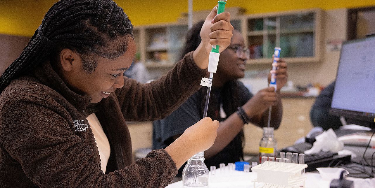 Students work at a biology lab bench.
