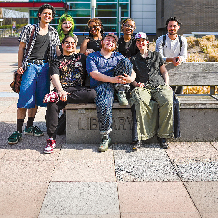 Group of students sits on a bench on SUNY Purchase campus